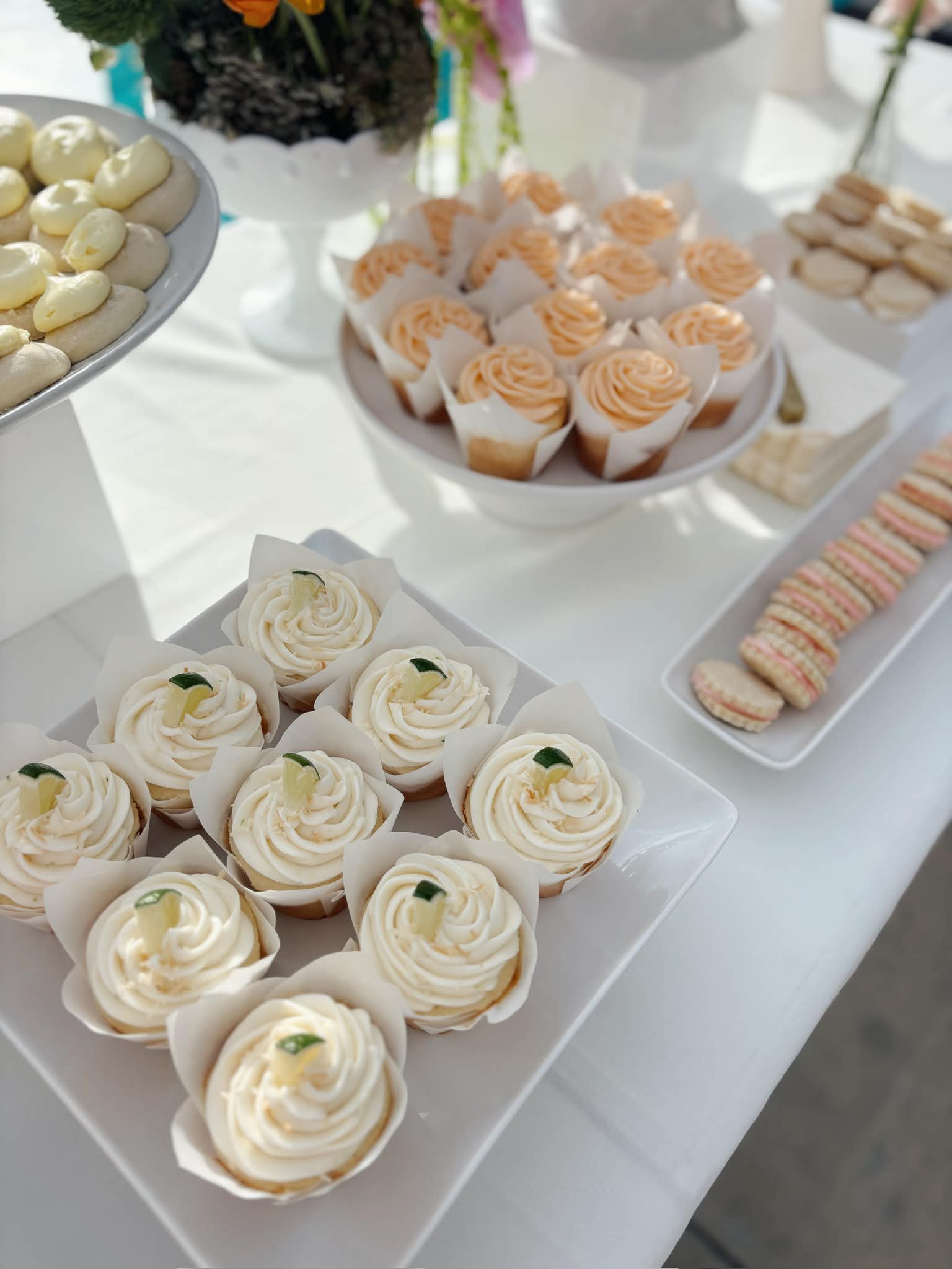 Cupcake dessert table with assorted flavors and macarons